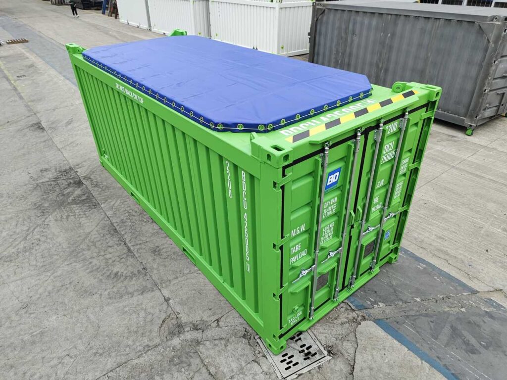 Green open top container with a blue tarpaulin roof cover