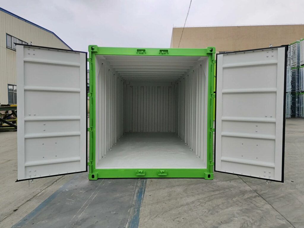 Inside of a green offshore container with both doors open, showing a plain light interior