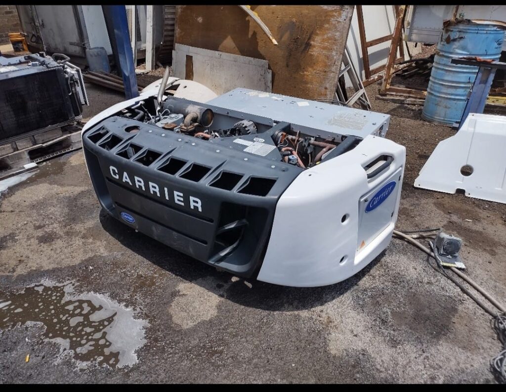 Carrier truck refrigeration unit with the front cover open, showing the engine compartment