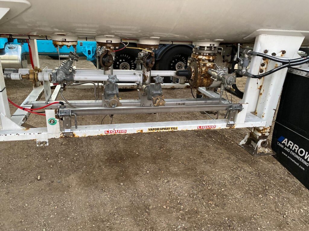 Valves, piping and pump equipment underneath the rear of a tank trailer
